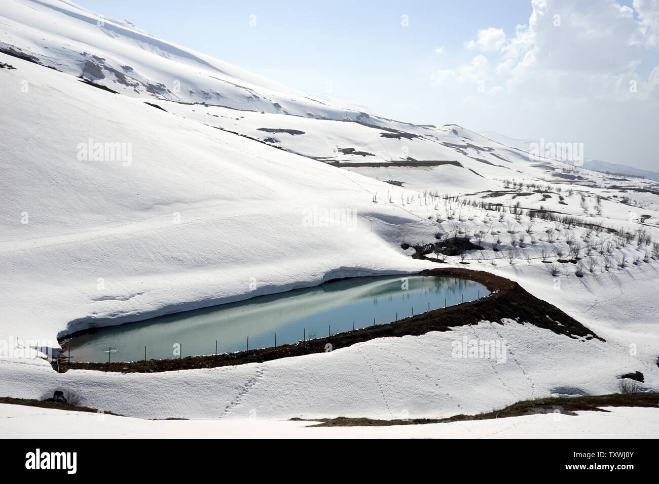 Stagno con acqua e neve montagna vicino a valle Quadisha in Libano Foto Stock