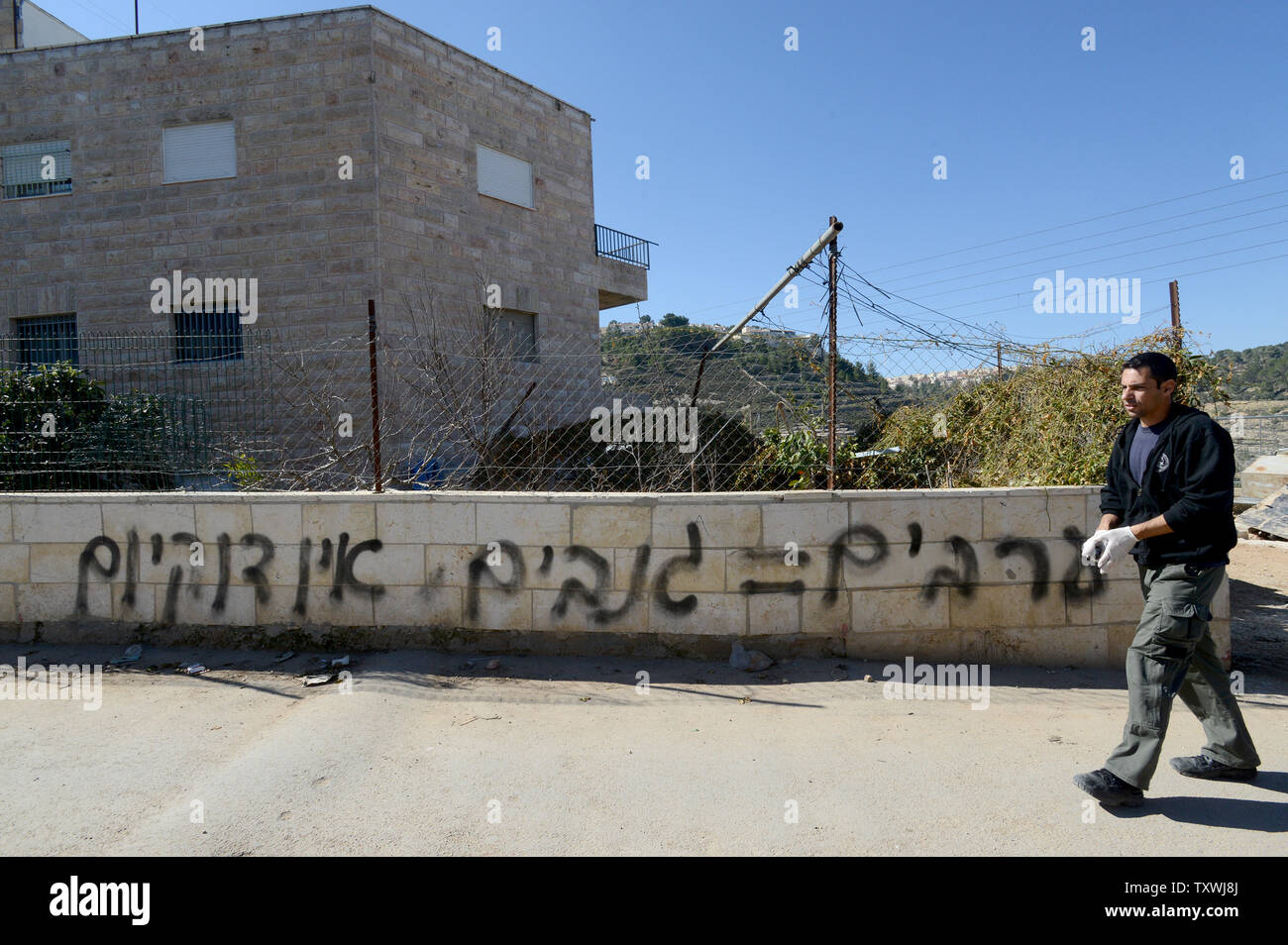 Un poliziotto israeliano passeggiate passato anti-arabi, razzista spraypainted graffiti su un muro durante un " prezzo Tag' aggressione da parte di estremisti ebrei nel quartiere Sharafat in Gerusalemme, Israele, 19 febbraio 2014. Il graffiti legge 'No coesistenza' e 'arabi = ladri". Più di 30 veicoli arabi avevano i loro pneumatici tagliati durante la notte durante il "prezzo Tag' attacchi che sono considerati una risposta diretta da lontano a destra israeliani ai colloqui di pace con i palestinesi. UPI/Debbie Hill Foto Stock