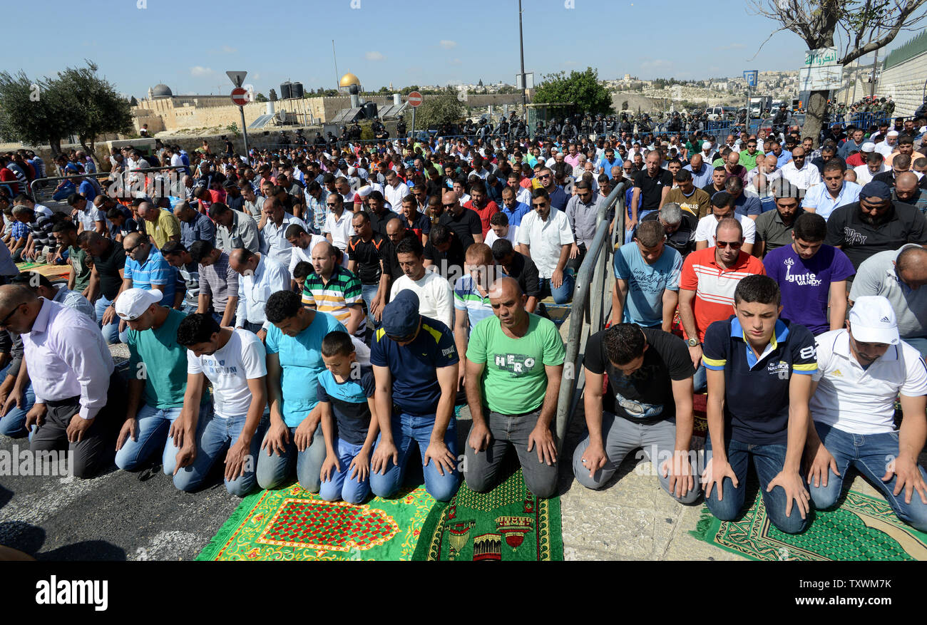 Palestinesi pregare sulla strada in Gerusalemme Est quartiere di Ras al-Amud dopo essere rifiutato l'ingresso a viaggiare per la Città Vecchia di Gerusalemme e la Moschea di Al-Aqsa composto, Ottobre 17, 2014. La polizia israeliana limitato l'ingresso dei musulmani palestinesi uomini sotto 50 anni dall'entrare il Al-Aqsa dovute a disturbi da palestinesi sul Monte del Tempio in precedenza questa settimana. UPI/Debbie Hill Foto Stock