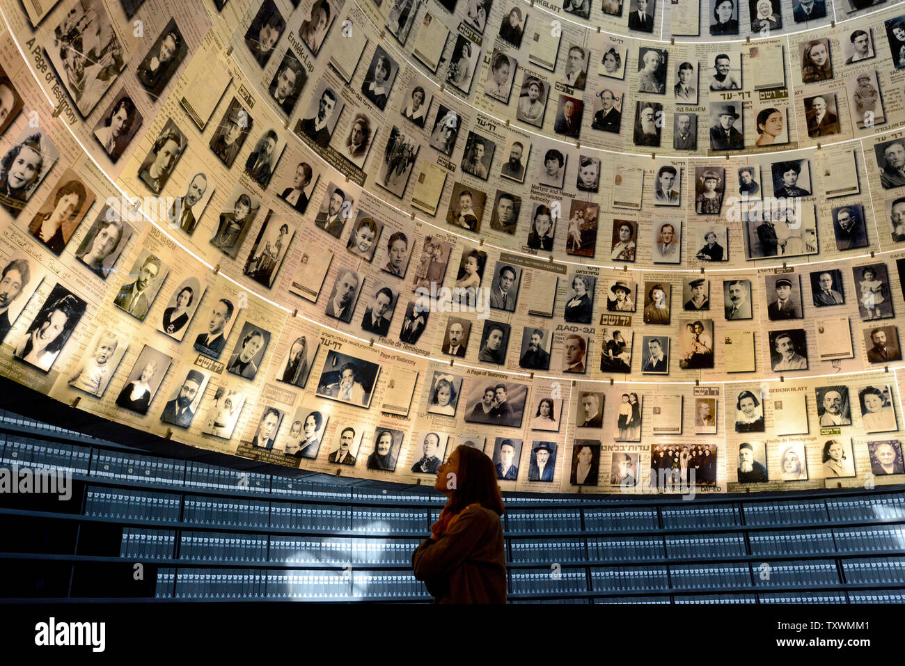 Una donna guarda i ritratti di ebrei uccisi dai nazisti durante la