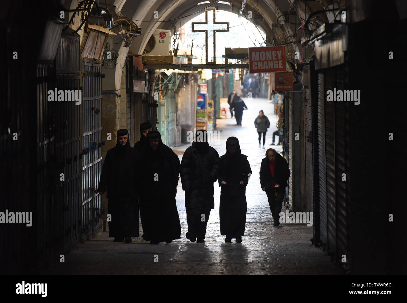 Le monache a piedi sotto una croce con il Mercoledì delle Ceneri nella Città Vecchia di Gerusalemme, 10 febbraio 2016. Il Mercoledì delle Ceneri è il primo giorno di Quaresima che inizia il santo periodo di digiuno e di preghiera. Essa cade 46 giorni prima Domenica di Pasqua e proviene dalla antica tradizione ebraica di penitenza e di digiuno. Le ceneri sono realizzati con i rami di palma di l'anno precedente la Domenica delle Palme e posto sul capo o sulla fronte a simboleggiare la polvere da cui Dio ha fatto gli esseri umani. Foto di Debbie Hill/ UPI Foto Stock