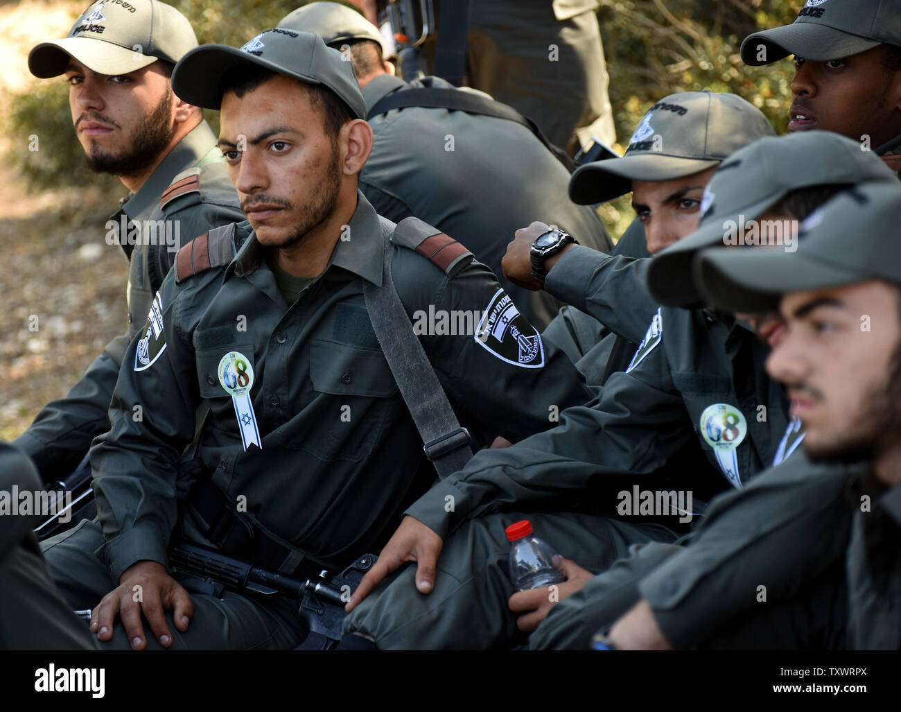 Frontiera israeliana polizia ascoltare superstite dell' Olocausto Eliezer Lev Sion, non visto, come egli condivide la sua testimonianza personale prima di un olocausto dei martiri ed eroi' Giorno del Ricordo alla cerimonia di inaugurazione di un Martire foresta vicino Moshav Kesalon, Israele, 5 maggio 2016. Sirene suonavano in tutto il paese il giovedì mattina, portare la vita a un arresto come gli israeliani hanno osservato un minuto di silenzio per onorare la memoria dei sei milioni di ebrei uccisi dai nazisti durante la Seconda Guerra Mondiale. Foto di Debbie Hill/UPI Foto Stock