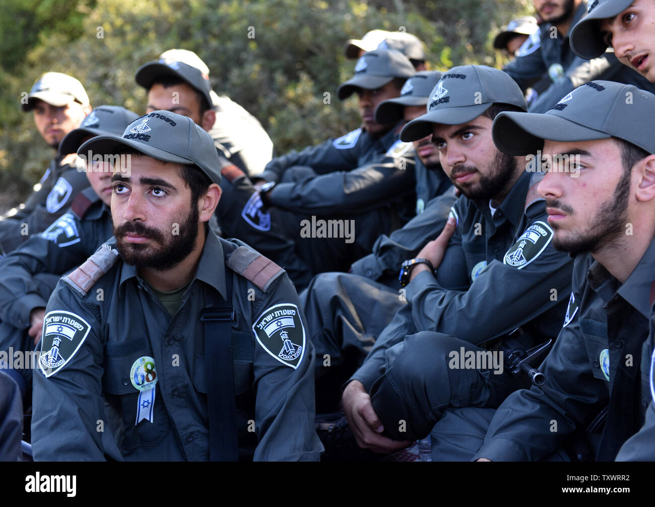 Frontiera israeliana polizia ascoltare superstite dell' Olocausto Eliezer Lev Sion, non visto, come egli condivide la sua testimonianza personale prima di un olocausto dei martiri ed eroi' Giorno del Ricordo alla cerimonia di inaugurazione di un Martire foresta vicino Moshav Kesalon, Israele, 5 maggio 2016. Sirene suonavano in tutto il paese il giovedì mattina, portare la vita a un arresto come gli israeliani hanno osservato un minuto di silenzio per onorare la memoria dei sei milioni di ebrei uccisi dai nazisti durante la Seconda Guerra Mondiale. Foto di Debbie Hill/UPI Foto Stock
