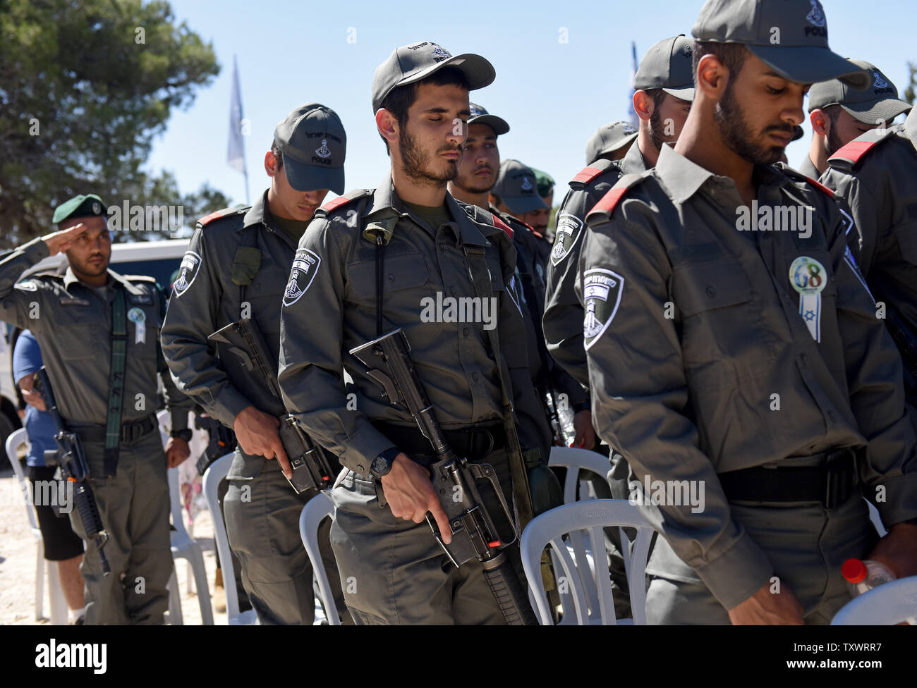 Frontiera israeliana di prua di polizia le loro teste durante un momento di silenzio in un olocausto dei martiri ed eroi' Giorno del Ricordo alla cerimonia di inaugurazione di un Martire foresta vicino Moshav Kesalon, Israele, 5 maggio 2016. Sirene suonavano in tutto il paese il giovedì mattina, portare la vita a un arresto come gli israeliani hanno osservato un minuto di silenzio per onorare la memoria dei sei milioni di ebrei uccisi dai nazisti durante la Seconda Guerra Mondiale. Foto di Debbie Hill/UPI Foto Stock