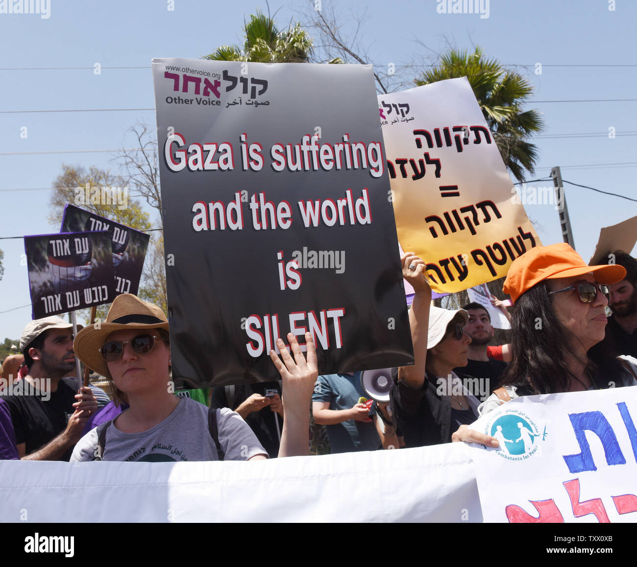 Manifestanti israeliani tenere indicazioni chiedendo al governo di fermare lo spargimento di sangue di palestinesi sulla frontiera Gaza a una dimostrazione a Yad Mordechai, Israele, vicino alla striscia di Gaza, 18 maggio 2018. Più di un centinaio di palestinesi sono stati uccisi dall'esercito israeliano a proteste lungo il confine Israel-Gaza nelle ultime settimane. Foto di Debbie Hill/UPI Foto Stock