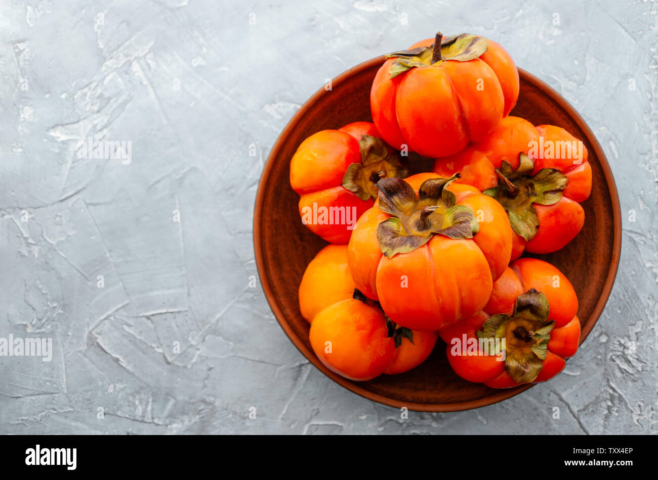 Arancione persimmon maturi frutti su uno sfondo luminoso. Sfondo con copia spazio, posto per testo, vista dall'alto Foto Stock