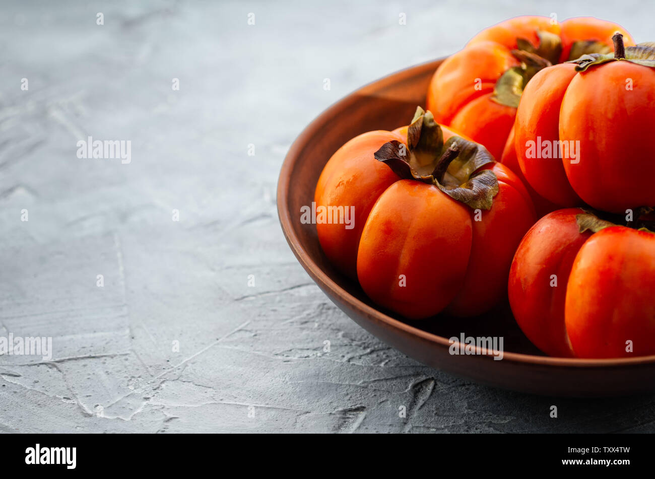 Arancione persimmon maturi frutti su uno sfondo luminoso. Sfondo con copia spazio, posto per testo, vista dall'alto Foto Stock