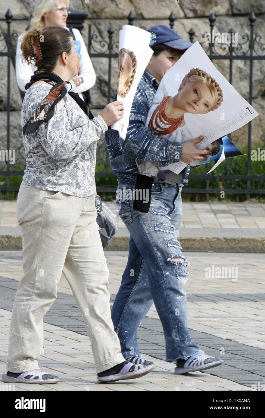 Giovani donne portano i manifesti con il leader dell opposizione Yulia Tymoshenko ritratto del centro di Kiev il 25 settembre 2007. Partiti politici ucraini preparati per la Domenica elezioni parlamentari impostando i campi tendati nel centro della capitale di chiamare per un libero e giusto voto. (UPI foto/Sergey Starostenko) Foto Stock