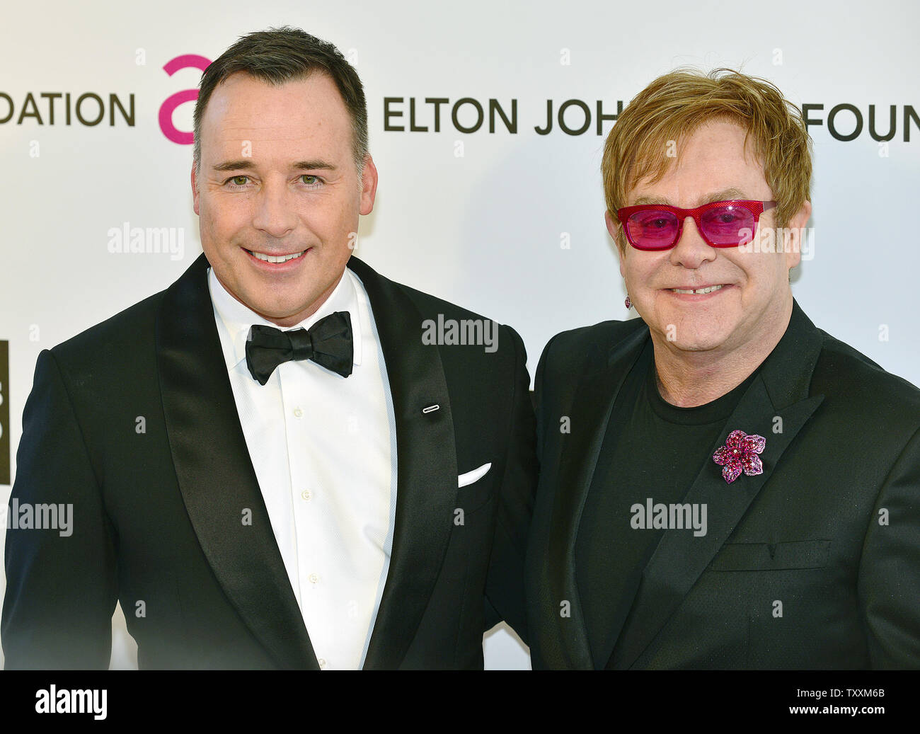 Elton John (R) e David arredare arriva ad ospitare il cantante del AIDS Foundation Academy Awards la visualizzazione delle parti a West Hollywood Park a Los Angeles il 24 febbraio 2013. UPI/Chris Chew Foto Stock