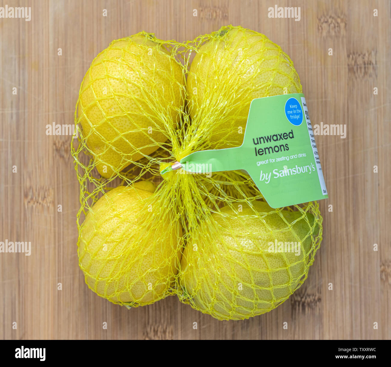 London / UK - 25 Giugno 2019 - Unwaxd limoni da Sainsburys in un pacco di quattro su uno sfondo di legno Foto Stock
