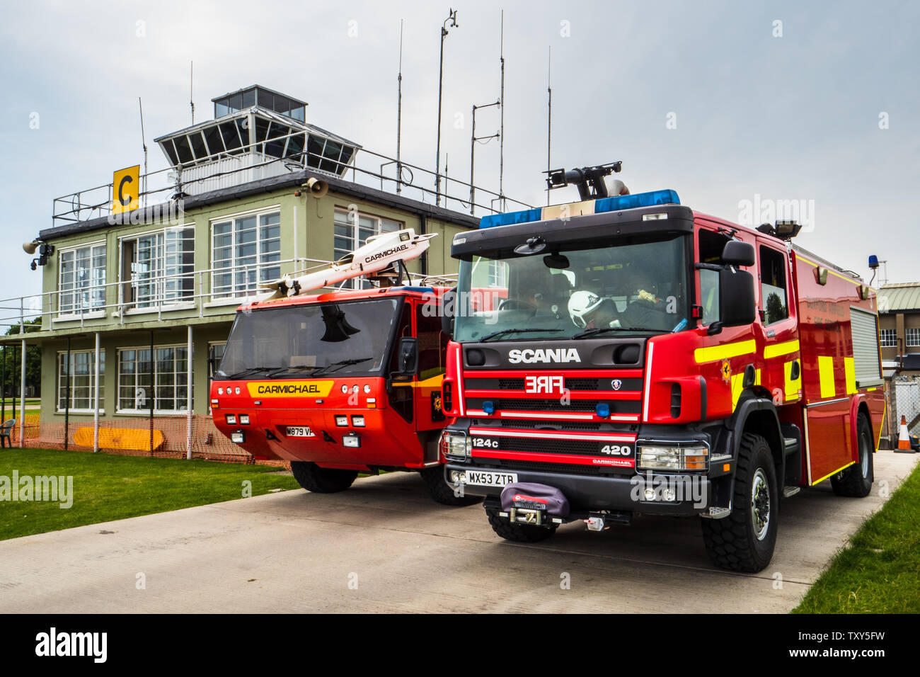 Aviosuperficie di servizio antincendio - Motori Fire presso il Museo Imperiale della Guerra airfield vicino a Cambridge Regno Unito, WW2 vintage della torre di controllo in background Foto Stock