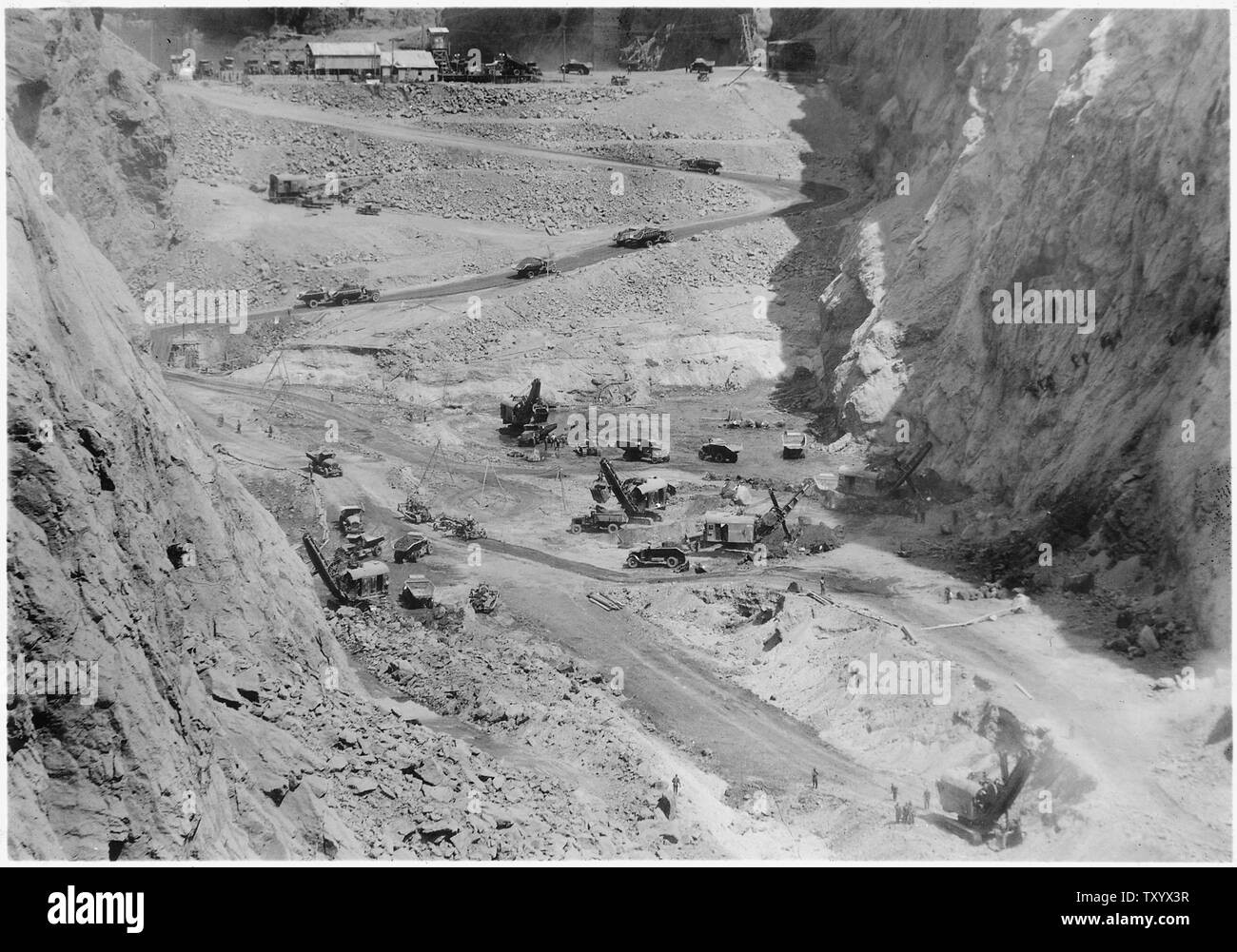 Concentrazione di attrezzature di scavo lavora in diga sito della sottostruttura. Questa mostra sei 3-1/2 pale di cantiere in zona. I carrelli sono alaggio bottino fuori oltre a monte di paratoia.; Portata e contenuto: fotografia dal volume due di una serie di album di foto per documentare la costruzione della Diga di Hoover, Boulder City, Nevada. Foto Stock