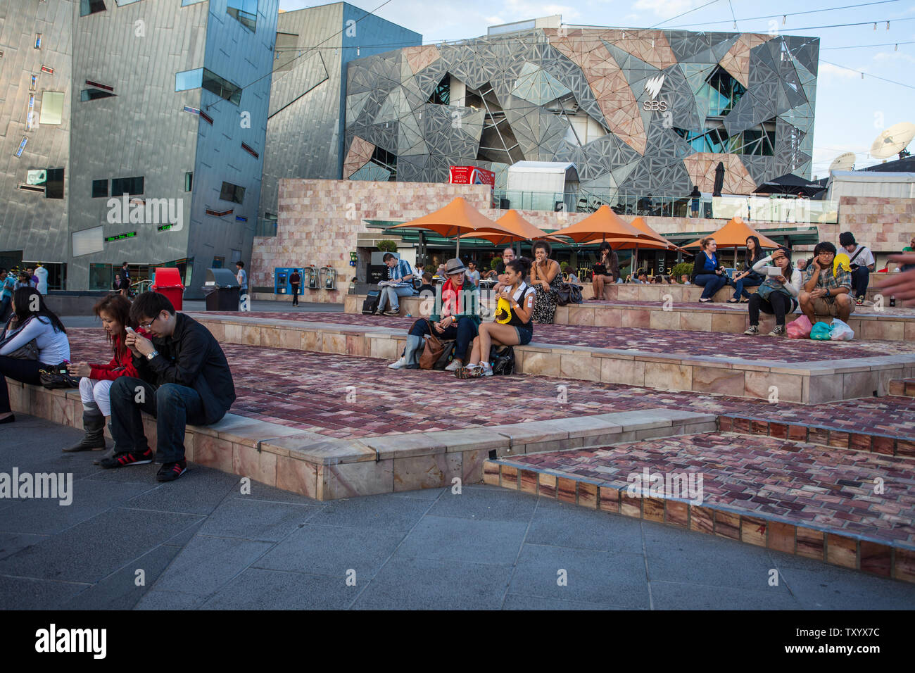 Persone non identificate rilassarsi in Federation Square, Melbourne, Australia Foto Stock