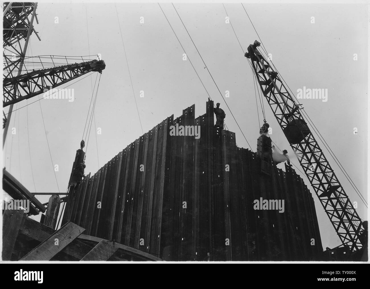 Costruzione di celle di paratoia. Il vapore battipali mettere giù una lamiera di acciaio.; Portata e contenuto: fotografia dal volume due di una serie di album di foto per documentare la costruzione del Grand Coulee Dam e i relativi lavori sul bacino di Columbia progetto. Foto Stock