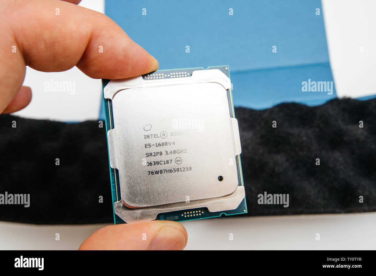 London, Regno Unito - 15 Maggio 2019: sopra vista macro di nuovo nuovo e potente E5-1680 V4 Intel Xeon professional processore CPU Broadwell FCLGA2011-3 man mano unboxing nuovo high tech dispositivo Foto Stock