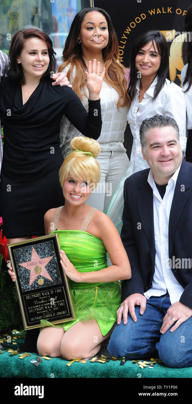 Tinker Bell, la fata personaggio che scaturiva dalle pagine di J.M Barrie della letteratura classica, 'Peter Pan', si inginocchia accanto al regista Bradley Raymond (R) e Mae Whitman, Raven-Symone e Pamela Adlon (L-R, posteriori), Tinker Bell è onorato con la 2,418th della stella sulla Hollywood Walk of Fame durante una cerimonia di inaugurazione a Los Angeles il 21 settembre 2010. UPI/Jim Ruymen Foto Stock