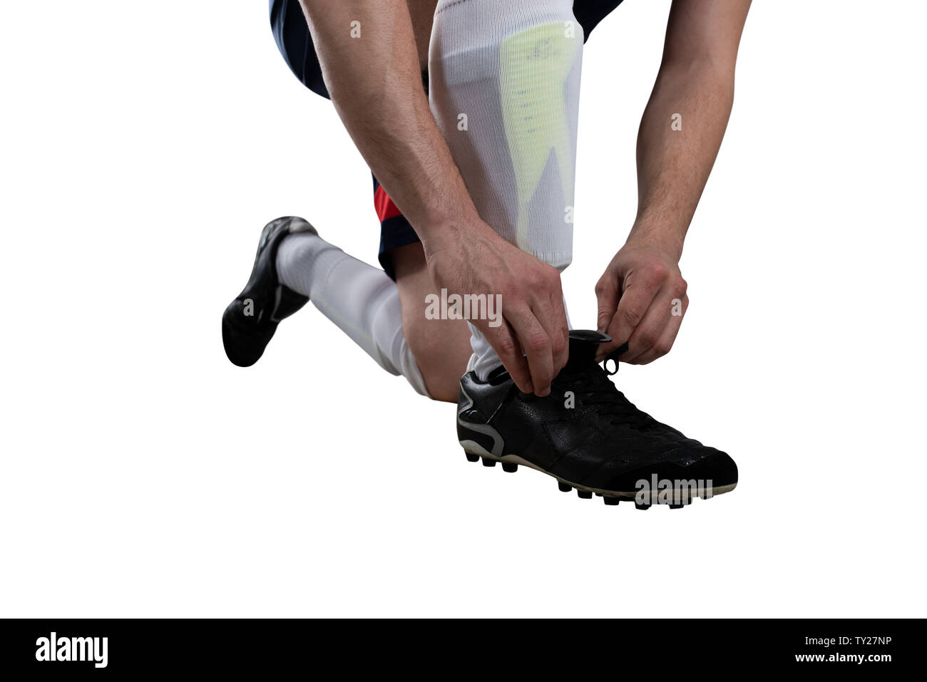 Giocatore di calcio regolare le sue scarpe prima della partita. Isolato su sfondo bianco Foto Stock