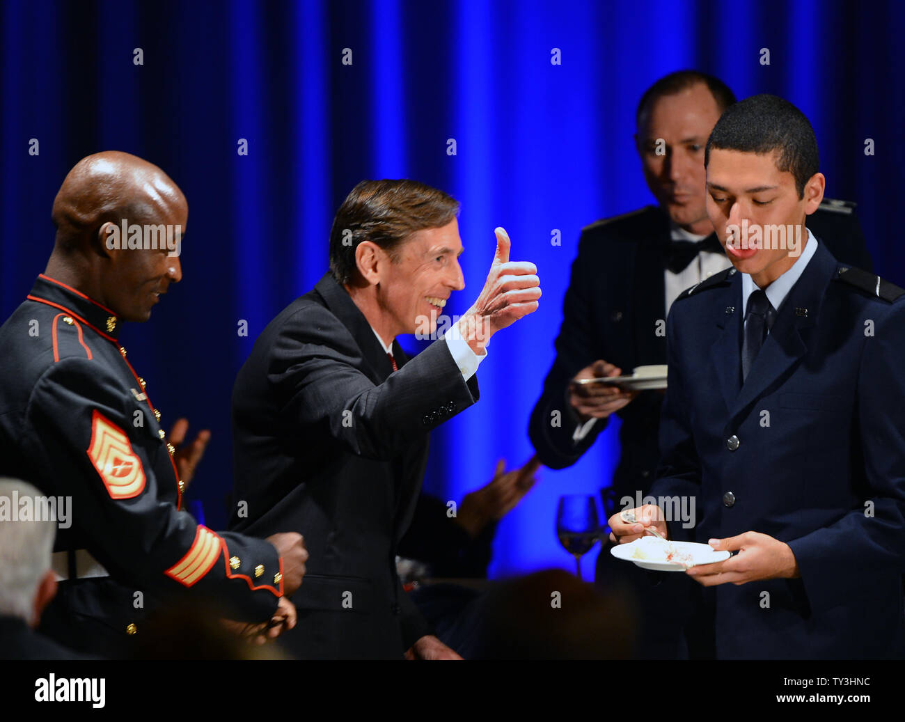 Ex direttore della CIA e si ritira a quattro stelle generale generale David Petraeus (C) dà un pollice in alto dopo la condivisione di una porzione di una fetta di torta con servizi armati ROTC Hector Sandoval (R), prima di effettuare il suo primo intervento pubblico dal dimissionario il direttore della CIA in una università della California del Sud la cena per gli studenti veterani ROTC e studenti a Los Angeles il 26 marzo 2013. Petraeus si è scusato nel suo discorso per la extraconiugali vicenda che ha concluso la sua carriera. UPI/Jim Ruymen Foto Stock