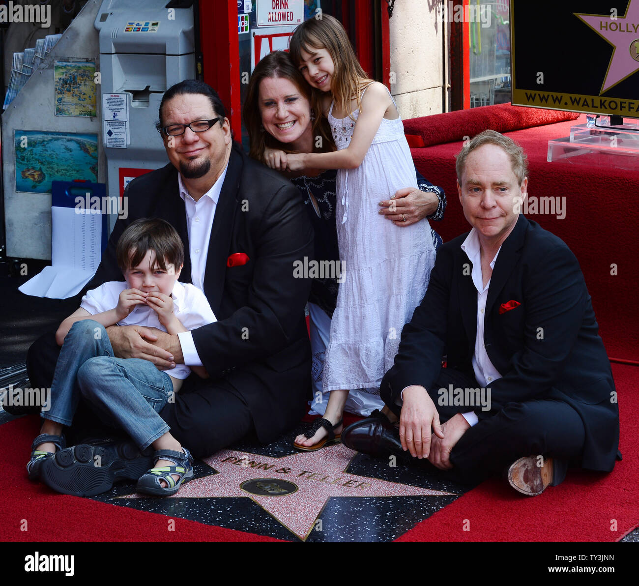 Penn Jillette (L) e Raymond Teller della commedia/magic duo Penn & Teller sedersi sulla cima di loro stella, durante una cerimonia di inaugurazione, onorando la coppia con la 2,494th della stella sulla Hollywood Walk of Fame a Los Angeles il 5 aprile 2013. La giunzione nella celebrazione è Jillette la moglie Emily Zolten e il loro figlio Zolten e figlia Moxie. UPI/Jim Ruymen Foto Stock