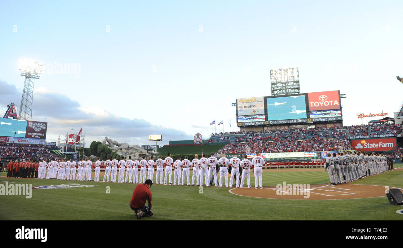 Il Los Angeles Angeli e Seattle Mariners stand per l'inno nazionale presso Angel Stadium di Anaheim, in California, il 31 marzo 2014. UPI/Lori Shepler. Foto Stock