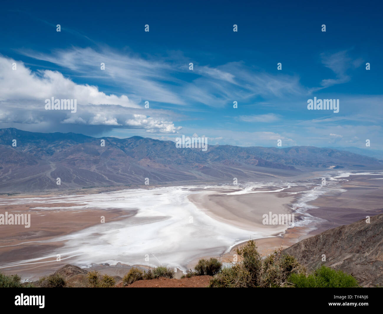 Dante in vista Parco Nazionale della Valle della Morte del fondovalle e sulle montagne circostanti (Panamint) con un cielo blu brillante e nuvole Foto Stock