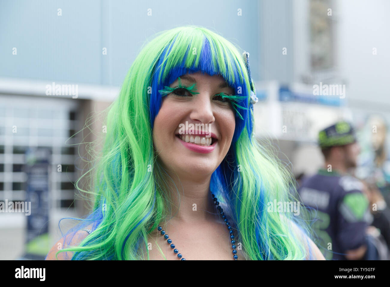 A Seattle Seahawks fan arriva alla home team stadium, indossando una lunga parrucca in team la firma i colori blu e verde su una giornata di gioco, Seattle, Stati Uniti d'America. Foto Stock