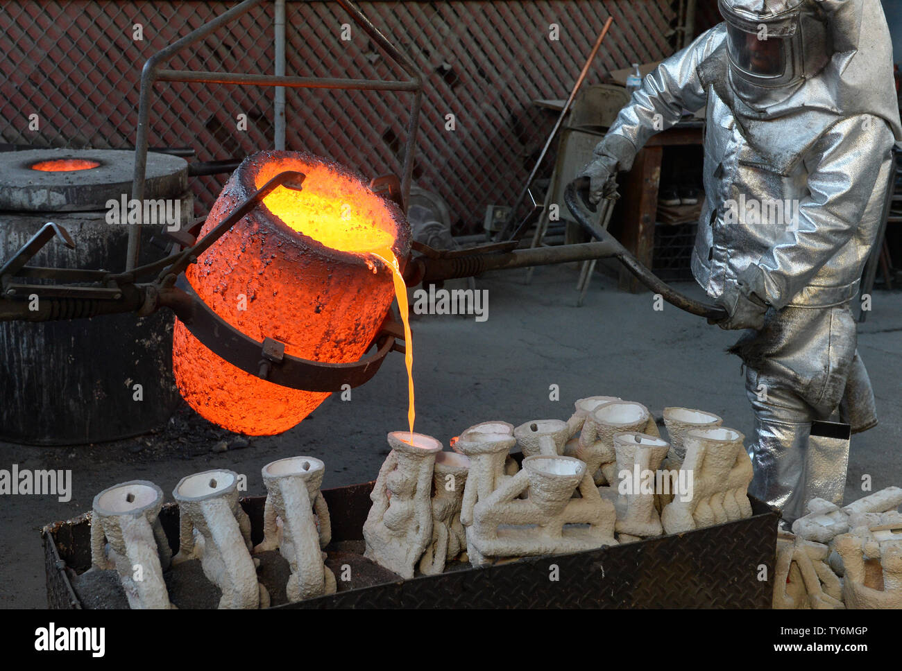 I lavoratori di fire adatta a versare in bronzo fuso di metallo in stampi durante la colata del premio di cooperativa di attori di schermo statuette presso la American Fine Arts Fonderia di Burbank, in California, il 17 gennaio 2017. I vincitori saranno annunciati durante una trasmissione in simulcast live su TNT e TBS a Los Angeles il 29 gennaio 2017. Foto di Jim Ruymen/UPI Foto Stock