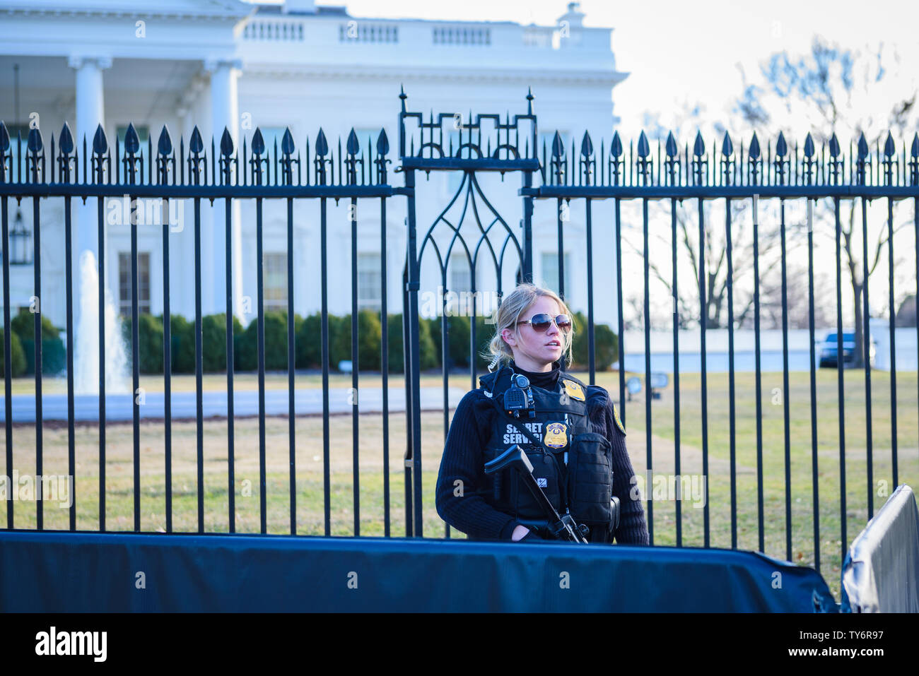 Washington, DC / STATI UNITI D'AMERICA - Circa Febbraio 2018: una femmina di agente dei servizi segreti visto al confine esterno della Casa Bianca armati con fucile Foto Stock