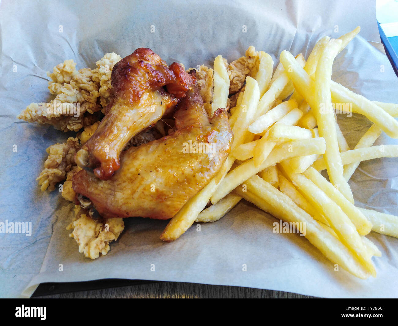 Alette di pollo fritte e patatine fritte. Foto Stock