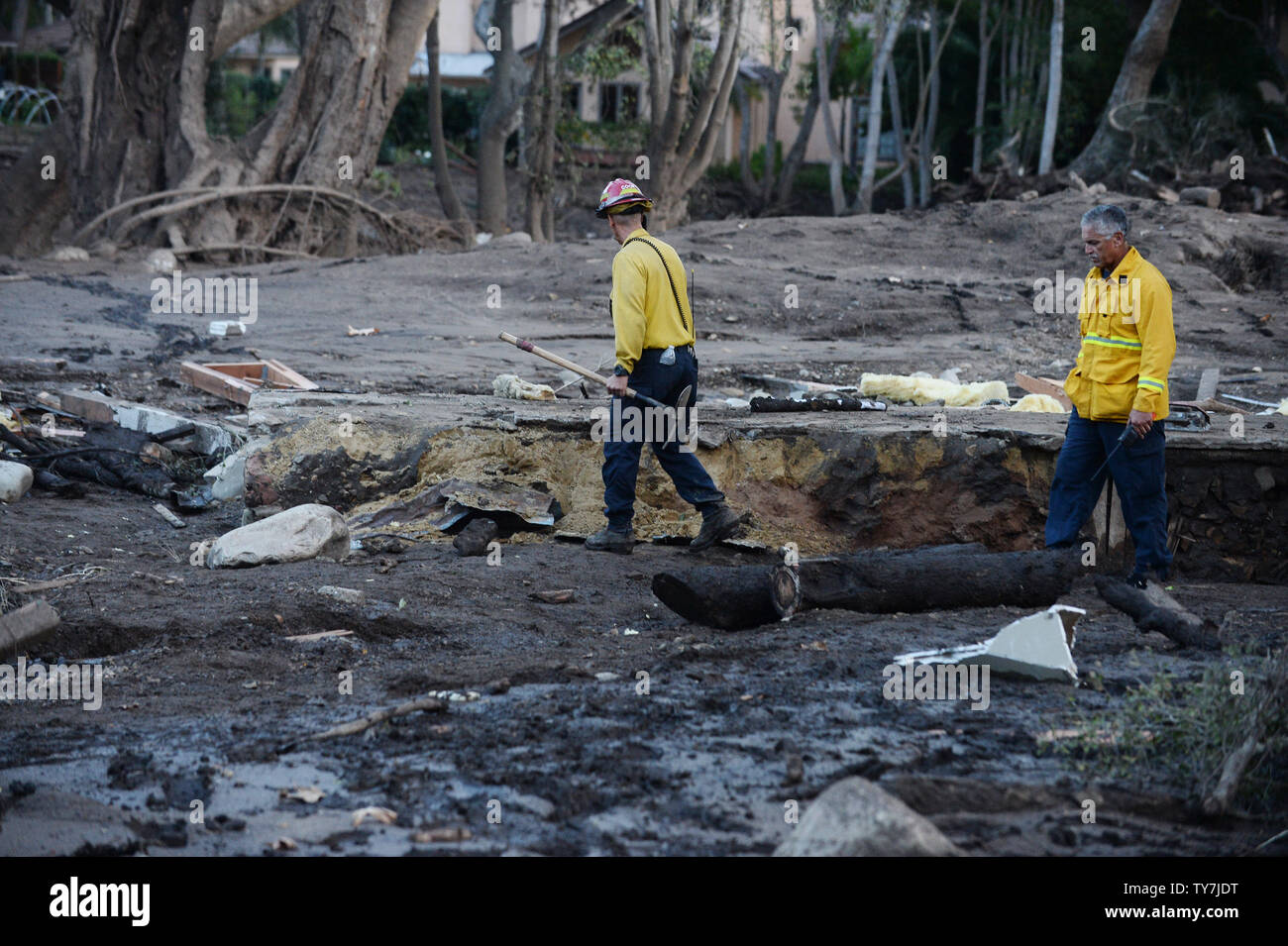 I vigili del fuoco a piedi attraverso il quartiere devastato su East Valley Road a seguito di martedì scorso della tempesta di pioggia in Montecito, la California il 13 gennaio 2018. Il numero dei morti potrebbe salire come gli equipaggi per continuare la ricerca attraverso circa trenta miglia quadrate di fango e detriti in Santa Barbara e Ventura contee. Rapporti di quanti restano assenti hanno variato in numeri, con Santa Barbara County Sheriff Bill Brown giovedì dicendo 5 persone restano ancora mancante, aggiungendo il pedaggio potrebbe fluttuare significativamente. Foto di Jim Ruymen/UPI Foto Stock