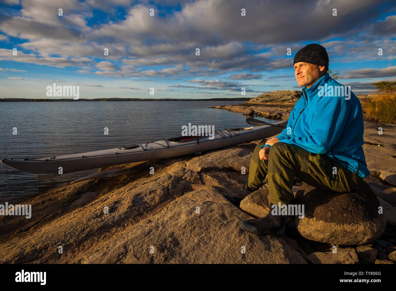 Fotografo Outdoor Øyvind Martinsen con il suo kayak nel lago Vansjø, Østfold, Norvegia. Vansjø è una parte dell'acqua sistema chiamato Morsavassdraget. Foto Stock