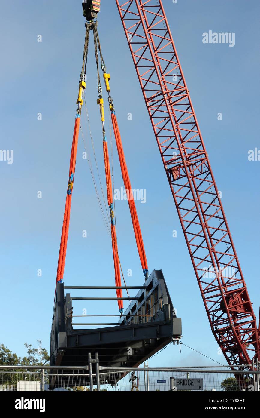 Sequenza di foto di grande gru di sollevamento sezione in acciaio del ponte ferroviario in posizione Foto Stock