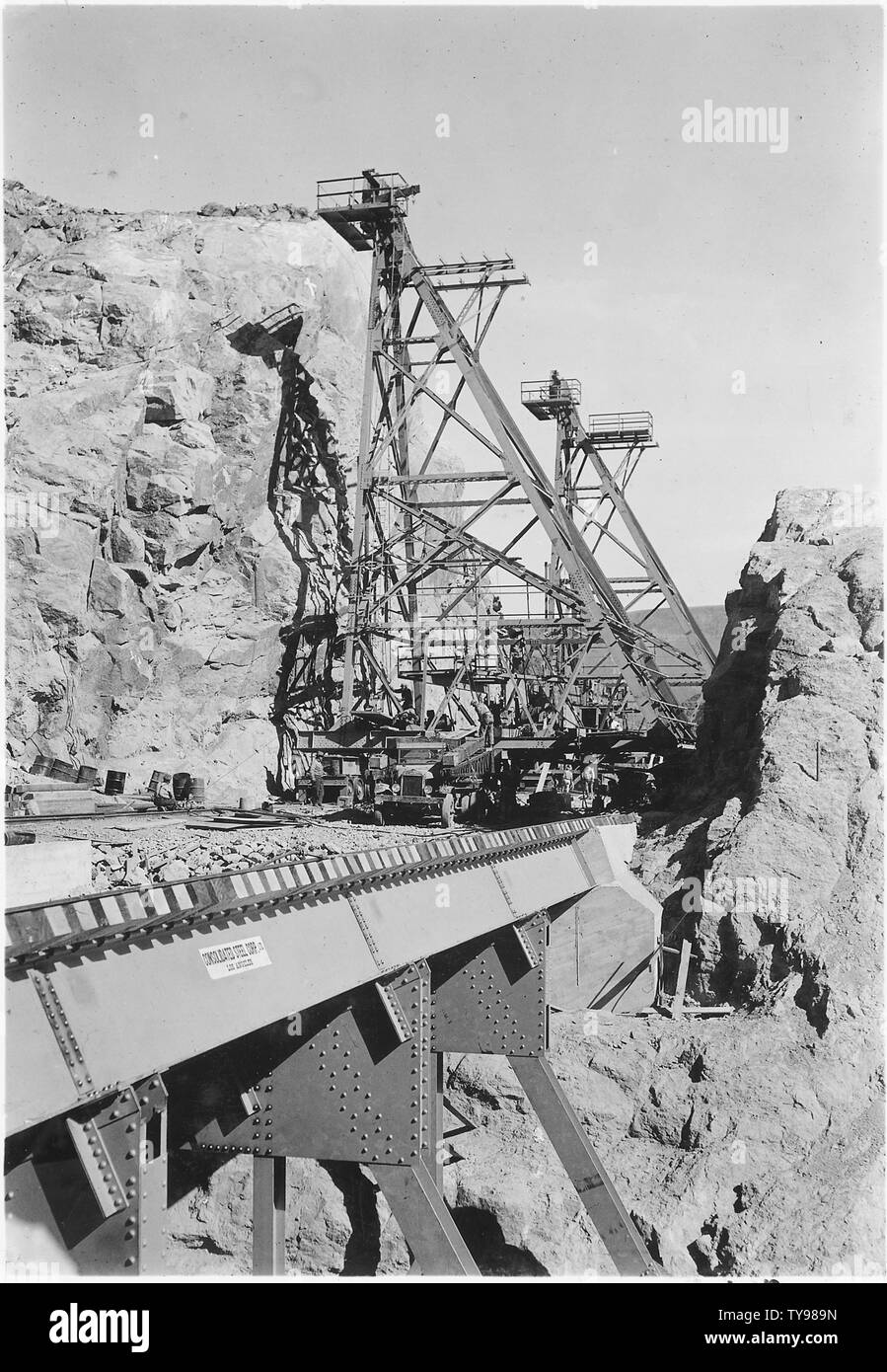 Funivia mobile torri in costruzione sul bordo laterale del Nevada. Rampa di spinta si vede in primo piano.; Portata e contenuto: fotografia dal volume due di una serie di album di foto per documentare la costruzione della Diga di Hoover, Boulder City, Nevada. Foto Stock