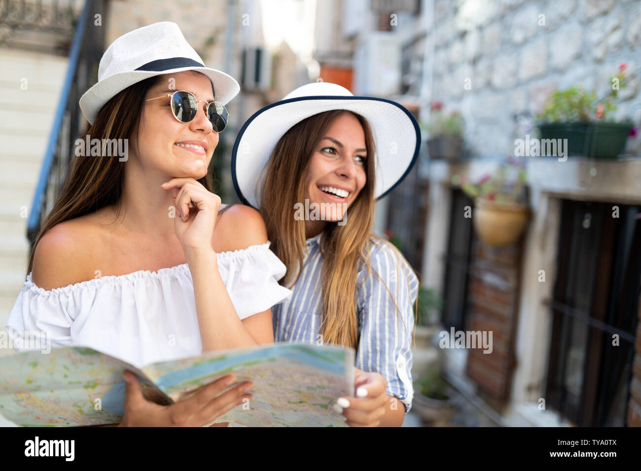 Sorridente girone di amici con la mappa. Turismo, Viaggi, Tempo libero, vacanze e concetto di amicizia Foto Stock