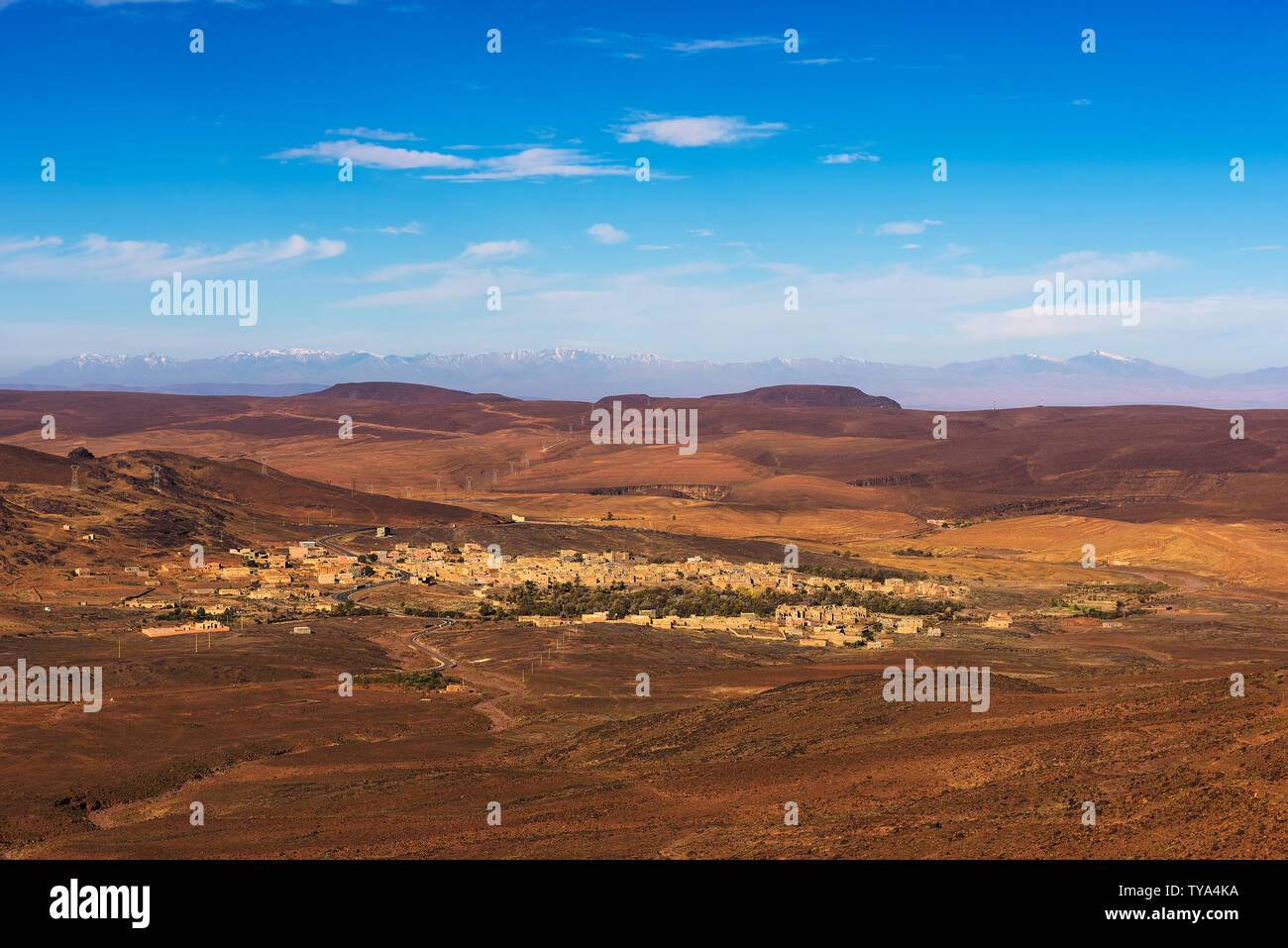 Vista su un villaggio in Marocco con innevate montagne Atlas in background Foto Stock