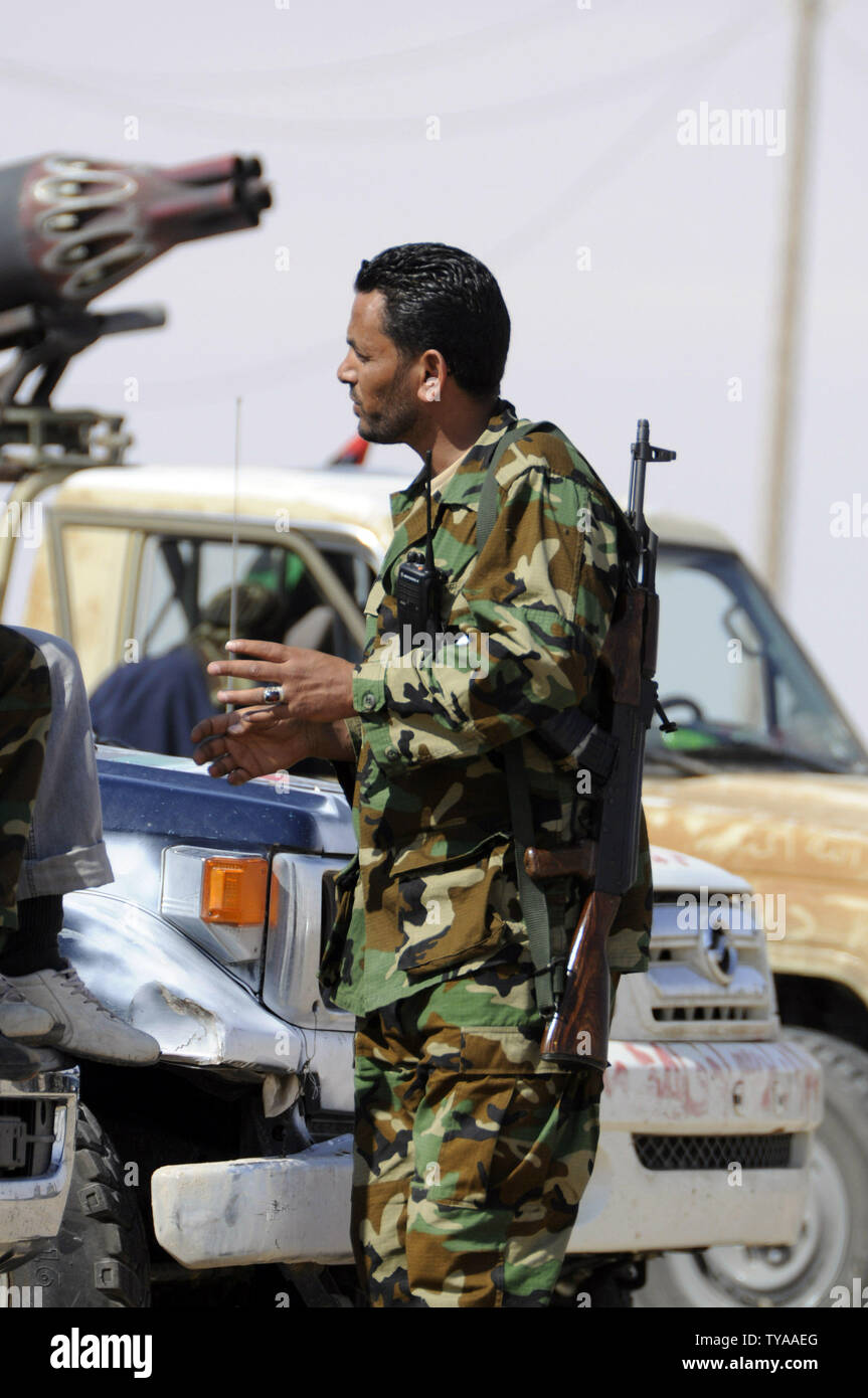 Un ribelle libico stare accanto a un veicolo armato presso la porta occidentale della strategic irrequieta città di Ajdabiya, il 20 aprile 2011. Francia e Italia hanno aderito la Gran Bretagna in invio consiglieri militari di insorti-held Libia orientale, come Tripoli ha avvertito che gli stivali stranieri sul suolo dovrebbe prolungare il conflitto. UPITarek Alhuony.. Foto Stock