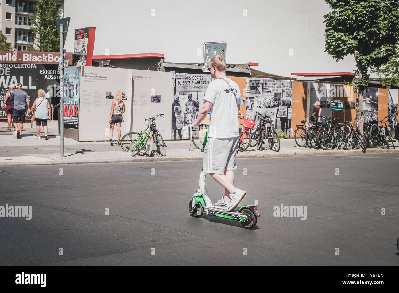Berlino, Germania - Giugno, 2019: il giovane uomo che cavalca scooter elettrico , escooter o e-scooter sulla strada di Berlino, Germania Foto Stock