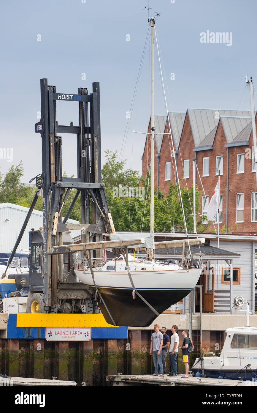 Uno yacht che viene sollevato fuori del fiume a Lymington, per ispezione e per pulizia o storage Foto Stock