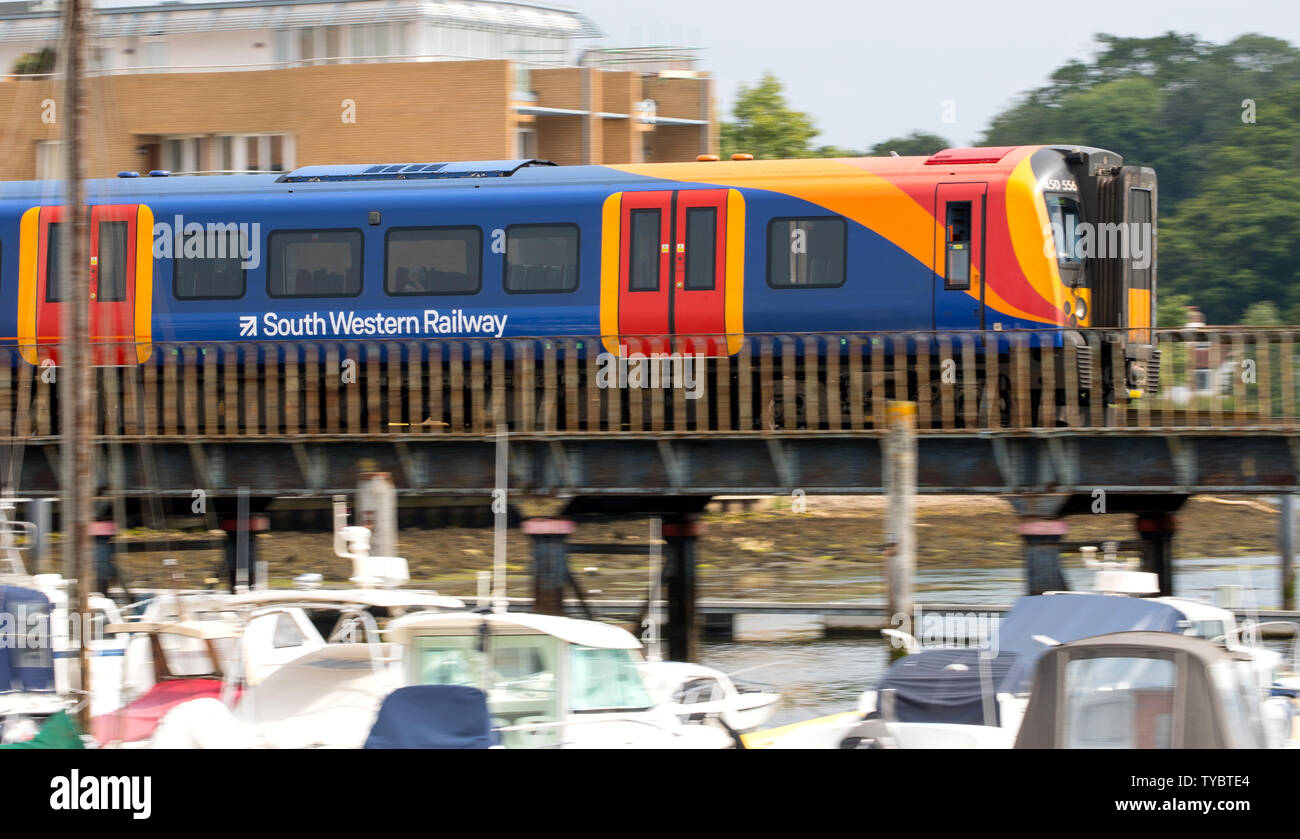 South Western Railway treno attraversando un ponte sul fiume a Lymington voce al traghetto Lymington Foto Stock