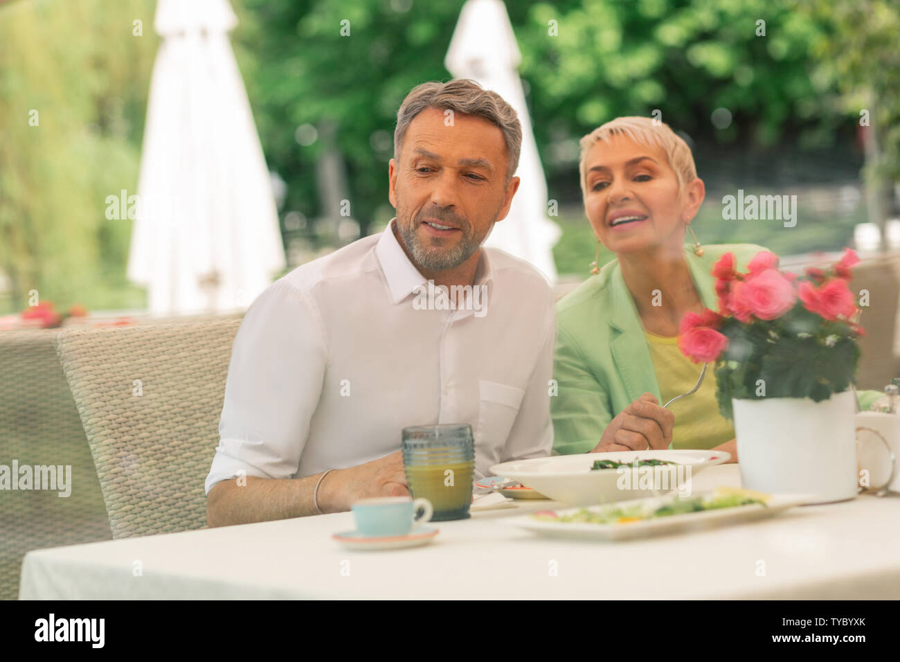 Grey-haired bel marito avente la colazione con la bella moglie Foto Stock