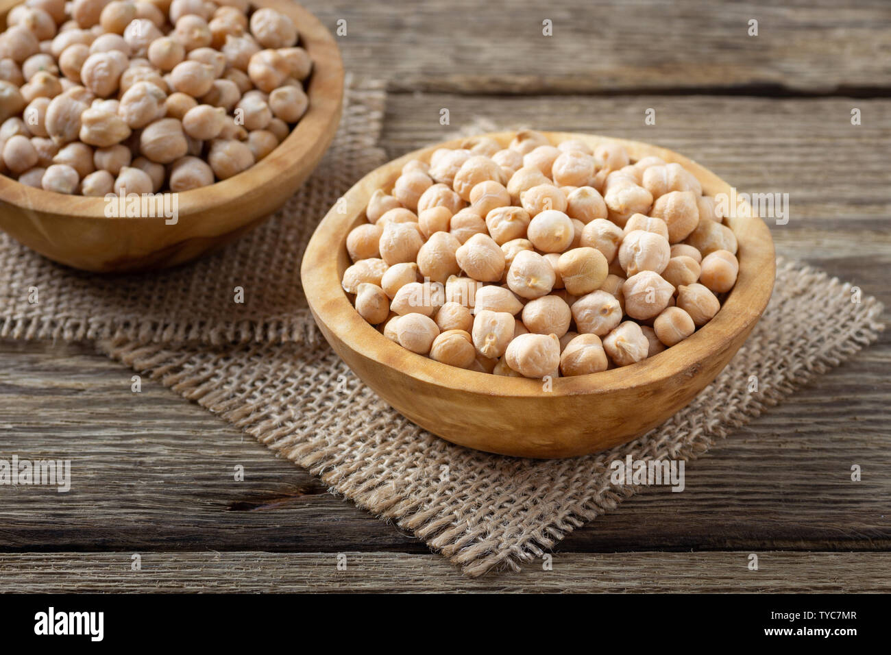 Nutriente-dense - cibo crudo grani di ceci in ciotola su una tavola di legno tavolo rustico Foto Stock Nutriente-dense - cibo crudo grani di ceci in ciotola su una tavola di legno tavolo rustico Foto Stock