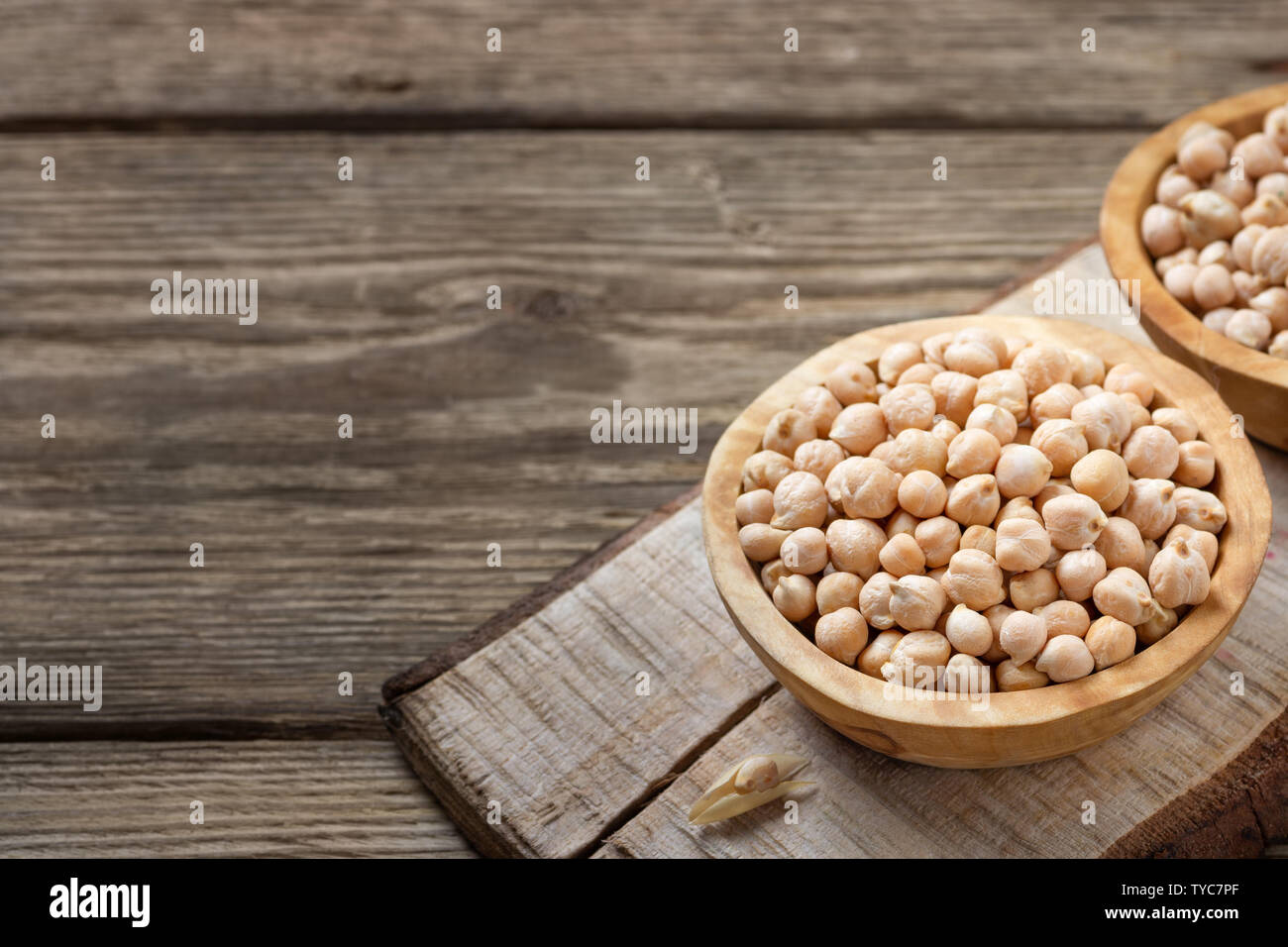 Nutriente-dense - cibo crudo grani di ceci in ciotola su una tavola di legno tavolo rustico. Copia spazio per il testo. Foto Stock Nutriente-dense - cibo crudo grani di ceci in ciotola su una tavola di legno tavolo rustico. Copia spazio per il testo. Foto Stock