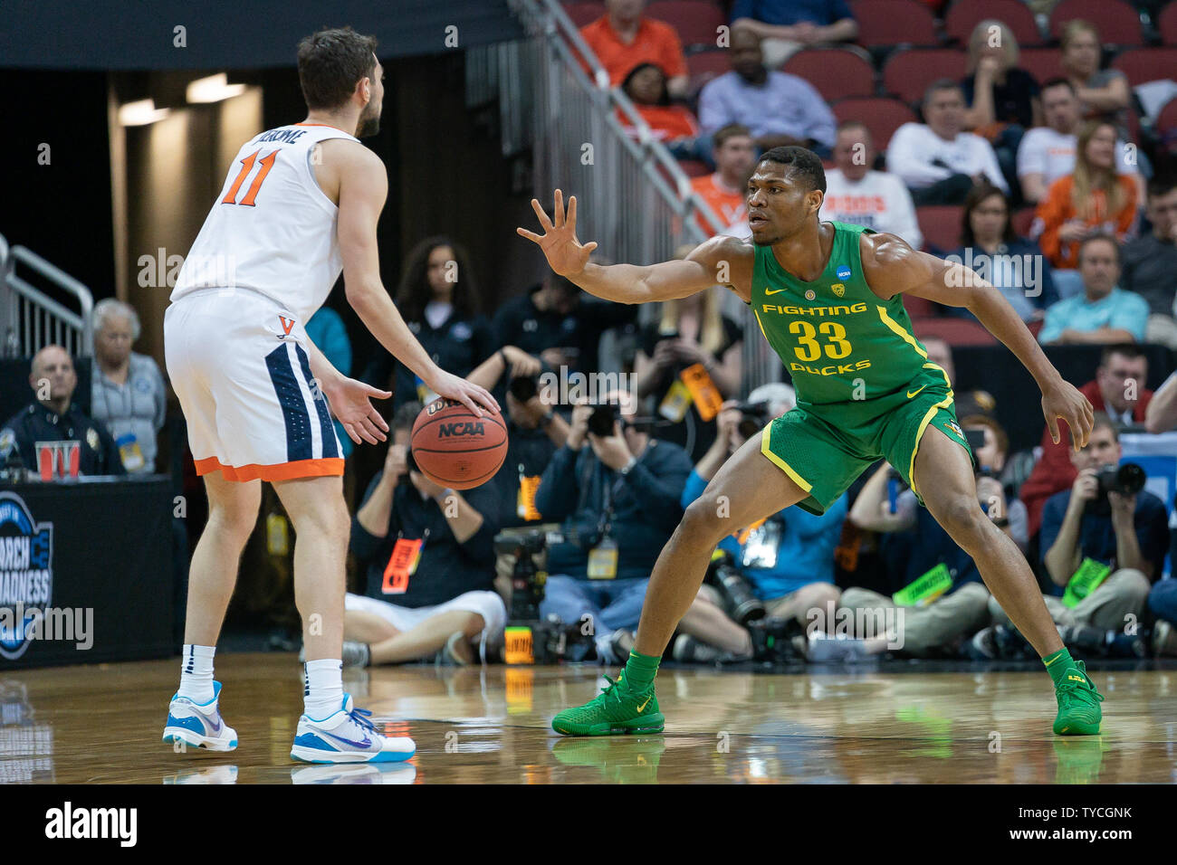 Virginia Cavaliers guard Ty Jerome (11) avanza la palla attorno Oregon Ducks avanti Francesco Okoro (33) durante il gioco regionale del 2019 NCAA Division I di pallacanestro degli uomini di torneo di KFC Yum Center di Louisville, Kentucky, Marzo 28, 2019. I Cavalieri sconfitto le anatre 53-49. Foto di Bryan Woolston/UPI Foto Stock