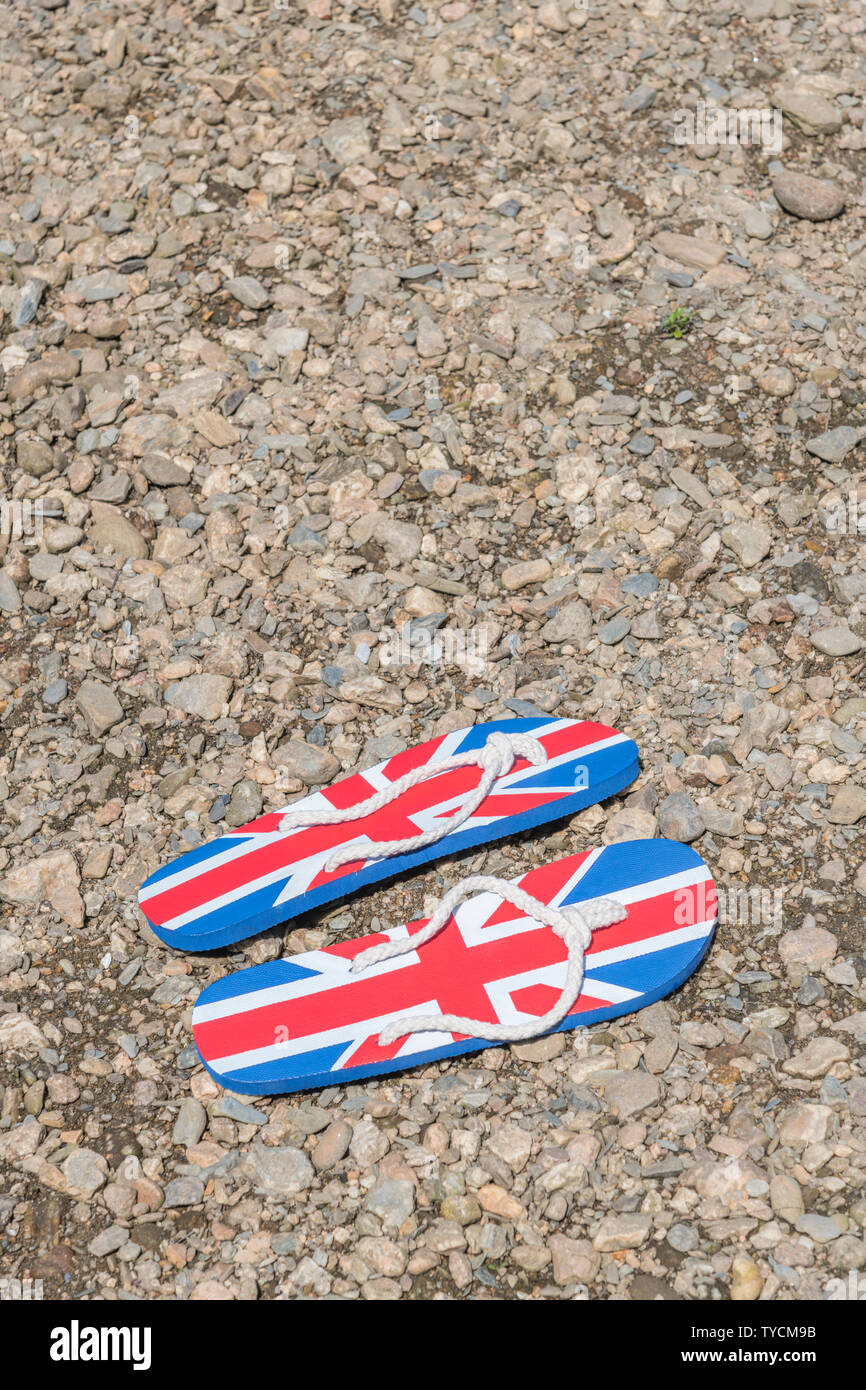 Union Jack flip-flop sul fiume Shingle - metafora 2021 Regno Unito staycation, vacanze a casa, staycation Cornwall, country break, flip flop calzature. Foto Stock