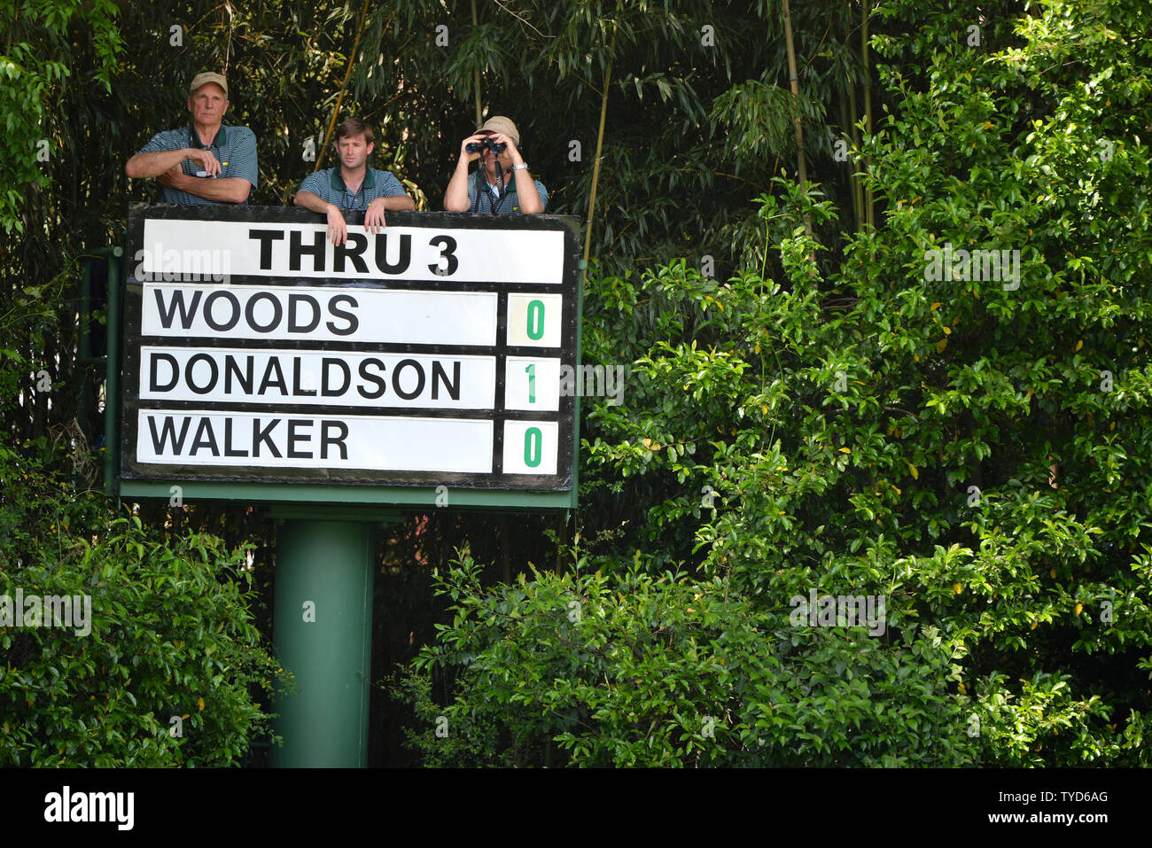 Tre uomini tendono un elevato consiglio di gruppo con Tiger Woods a anche par al 4° foro nel primo round 2015 Masters a Augusta National Golf Club di Augusta, in Georgia il 9 aprile 2015. Foto di Kevin Dietsch/UPI Foto Stock