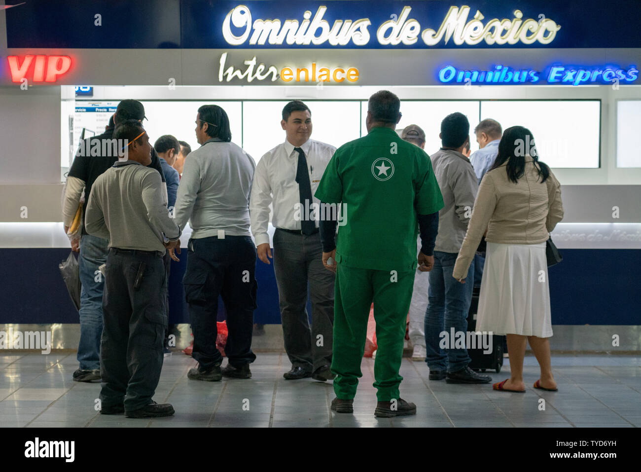 Un gruppo di migranti stand in linea con regolari di passeggeri per i biglietti del bus guidato dalla stazione dipendenti presso la stazione centrale degli autobus dopo che essi sono stati deportati in Messico il 24 gennaio 2019 in Matamoros, Messico. Molti saranno in viaggio in autobus o in famiglia torna ai loro rispettivi paesi in America centrale. Il Trump i piani di amministrazione per iniziare a inviare alcuni richiedenti asilo torna in Messico per attendere la risoluzione della loro elaborazione di immigrazione questa settimana, Department of Homeland Security funzionari ha detto giovedì. Foto di Ken Cedeño/UPI Foto Stock