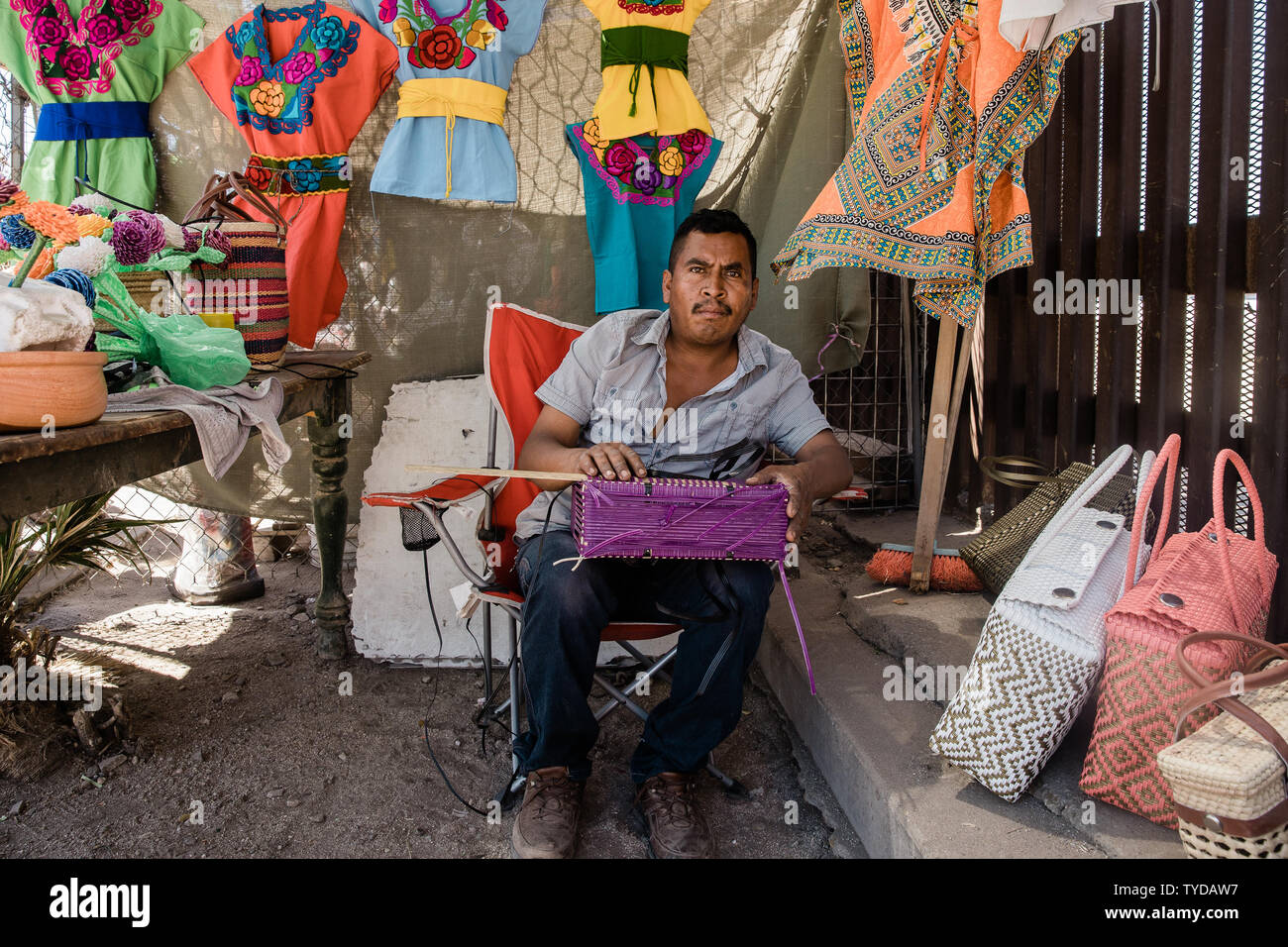 Juan tesse un portamonete sotto l'ombra accanto a la recinzione di confine che divide gli Stati Uniti e il Messico in Mexicali, in data 4 aprile 2019. Juan ha lavorato vicino la recinzione di confine per un periodo di dieci anni che vendono vestiti da oaxaca, Messico. Foto di Ariana Drehsler/UPI Foto di Ariana Drehsler/UPI Foto Stock Juan tesse un portamonete sotto l'ombra accanto a la recinzione di confine che divide gli Stati Uniti e il Messico in Mexicali, in data 4 aprile 2019. Juan ha lavorato vicino la recinzione di confine per un periodo di dieci anni che vendono vestiti da oaxaca, Messico. Foto di Ariana Drehsler/UPI Foto di Ariana Drehsler/UPI Foto Stock