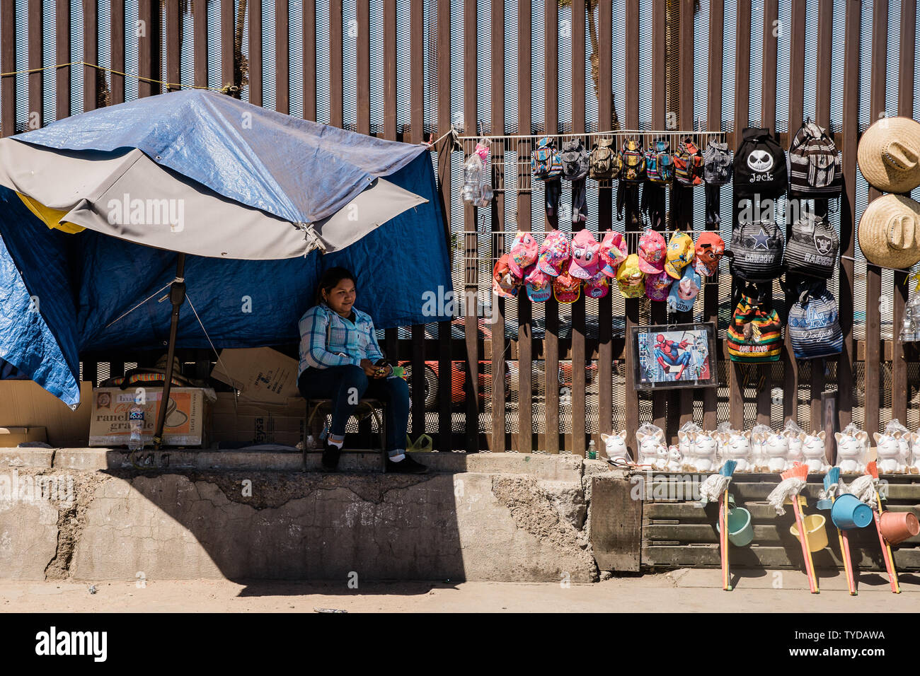 Una strada peddler vende souvenir accanto a la recinzione di confine che divide gli Stati Uniti e il Messico in Mexicali, Messico il 4 aprile 2019. Presidente Trump retrocede minaccia di arrestare la frontiera degli Stati Uniti con il Messico per arrestare attraversamenti di immigrati e dà il Messico un anno di avvertimento. Foto di Ariana Drehsler/UPI Foto Stock Una strada peddler vende souvenir accanto a la recinzione di confine che divide gli Stati Uniti e il Messico in Mexicali, Messico il 4 aprile 2019. Presidente Trump retrocede minaccia di arrestare la frontiera degli Stati Uniti con il Messico per arrestare attraversamenti di immigrati e dà il Messico un anno di avvertimento. Foto di Ariana Drehsler/UPI Foto Stock