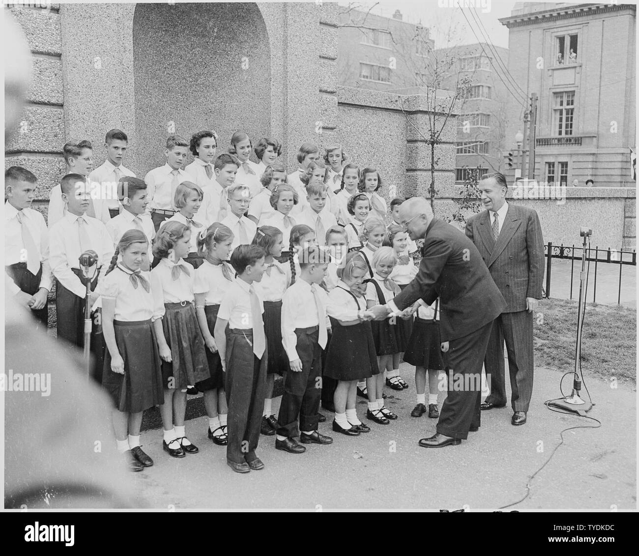 Fotografia del Presidente Truman stringono le mani con un gruppo di bambini a Meridian Hill Park a Washington, durante le cerimonie che segnano l'accettazione di un carillon come un dono dai Paesi Bassi verso gli Stati Uniti, presentato dalla Regina Juliana. Foto Stock