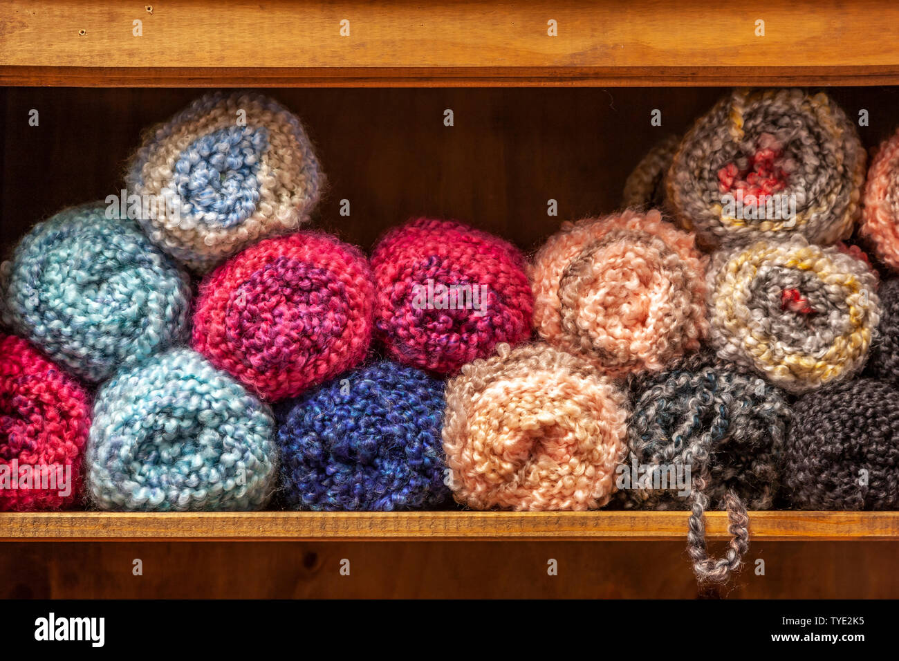 Lana per maglieria impilati su un ripiano. Foto Stock